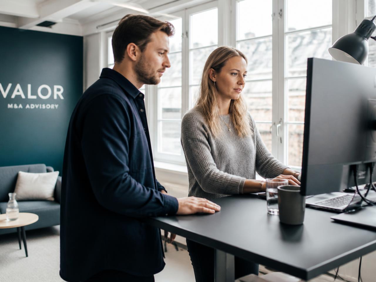 Salgsteam arbejder sammen foran skærmen